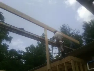 Carpenter setting a ridge beam over a new addition frame — Ice Dam Removal by Roofing Brothers in Mayslick