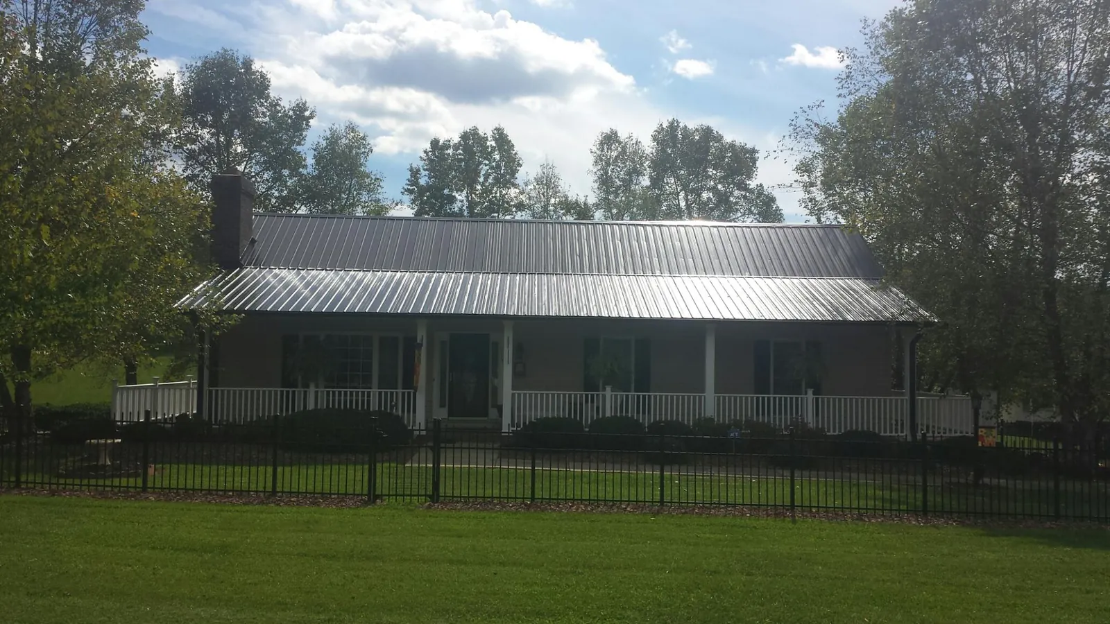 Gray metal roof on a brick ranch with a full width front porch — Gutter Guard Installation work by our crew in Mayslick