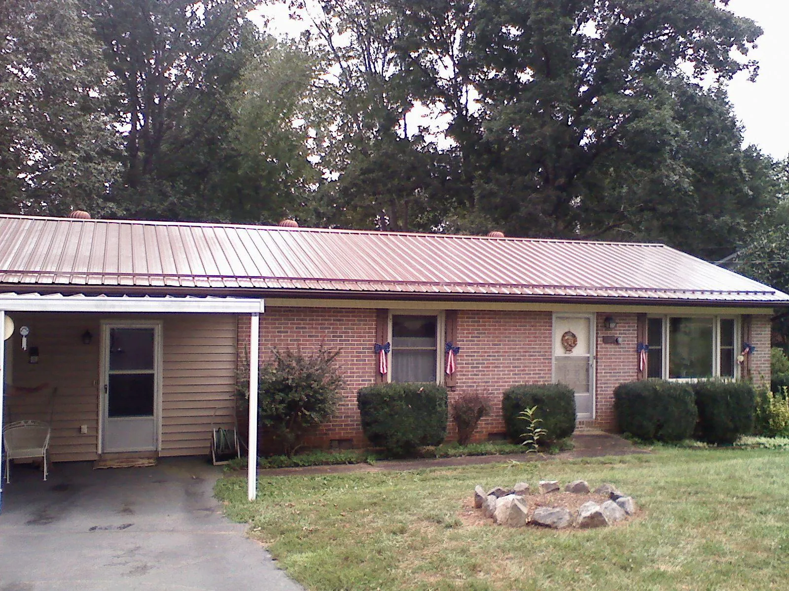 Bronze metal roof and carport on a brick ranch home — Roof Repair work by our crew in Mayslick